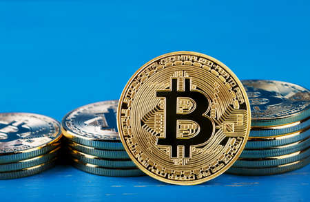 Gold bitcoin against the background of increasing stacks of bitcの写真素材