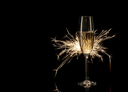 Tall glass of champagne in the glow of Bengal lightsの写真素材