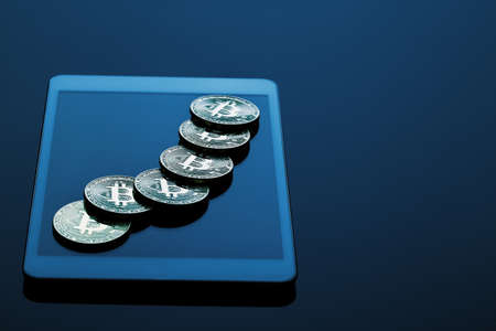 Stack of bitcoins on tablet computerの写真素材