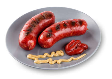 Sausages lying on gray  plate with mustard and ketchupの写真素材