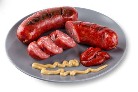 Sliced roasted sausages on gray plate with ketchupの写真素材