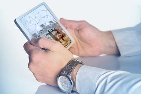 Hands of businessman with tablet and bitcoin on the screen