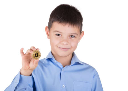 Young boy in blue shirt is holding bitcoins and smilingの写真素材