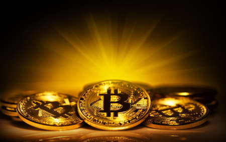 Golden bitcoins shining in bright lightの写真素材
