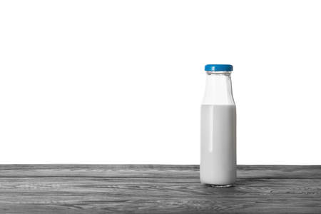 Bottle of milk on wooden table isolated on white backgroundの写真素材