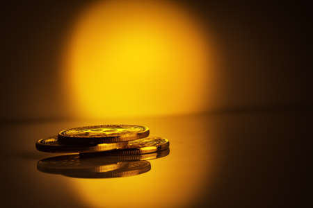 Stack of coins bitcoin on yellow with black background. The concept of a new currency and the development of a virtual business.の写真素材