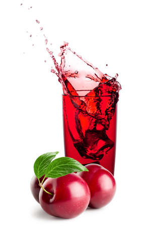 Glass of plum juice with splash and berriesの写真素材