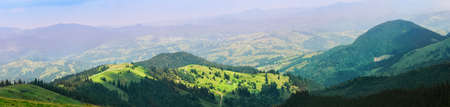 Village is in the mountains on green meadows. Summer landscape. Panoramaの写真素材
