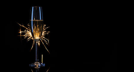 Tall glass of champagne with Bengal lightsの写真素材