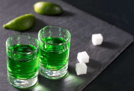 Two glasses with green absinthe lime and sugarの写真素材