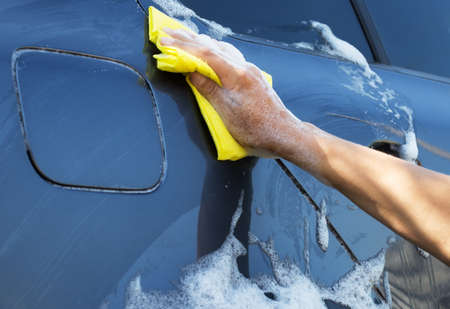 Gray car washing with yellow spongeの写真素材