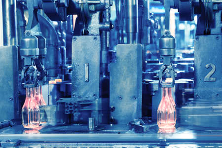 The hot glass bottles on conveyor are made by the glass manufact
