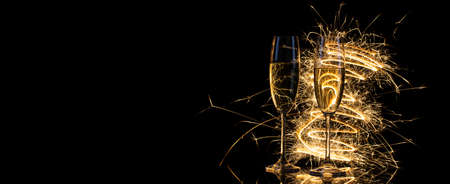 Glasses with champagne in the golden light of Bengal lightsの写真素材