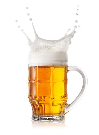 Splash in a faceted beer mug isolated on white backgroundの写真素材