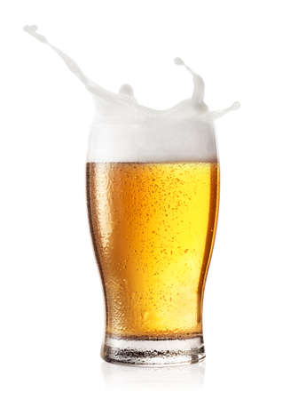Splash in a glass of beer isolated on white backgroundの写真素材
