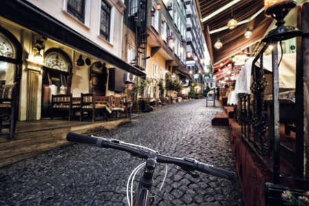 Bicycle steering wheel on the background of a bright city street with lighted lanternsの写真素材
