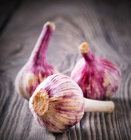 Three heads of garlic on a wooden tableの写真素材