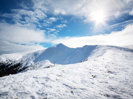 Mountain peak in the snow under the bright sunの写真素材