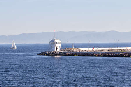 Pier with lighthouse and yacht in sea of Bosphorusの写真素材