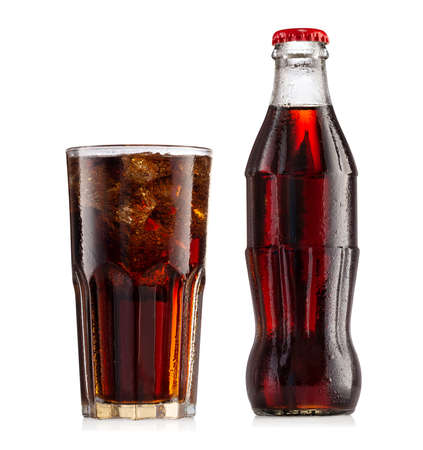 Brown carbonated drink in wet bottle with red cap and glass with iceの写真素材