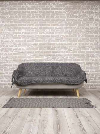 Background with brick wall and wooden floor with sofa in middleの写真素材