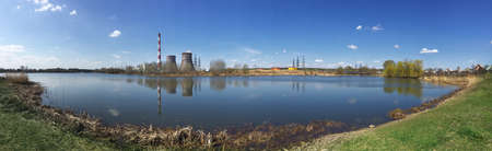 Panorama of lake with pipes of power station on shoreの写真素材