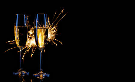 Two glasses of champagne and sparklers on black backgroundの写真素材