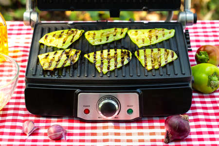 Green fried bell pepper lies on grillの写真素材