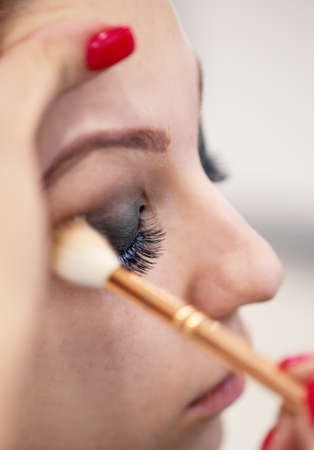 Girl's eyelids are made up in a beauty salonの写真素材