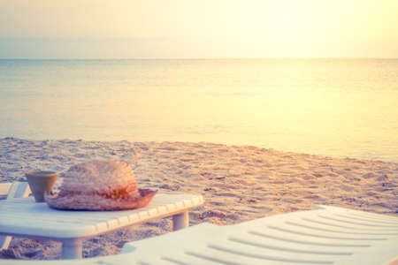 Straw hat on a deck chair on the shore. Vintage toning. Sharpness in the middle ground. Travel and vacation conceptの写真素材