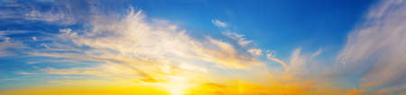 Panorama of the evening dramatic sky with bright sunの写真素材