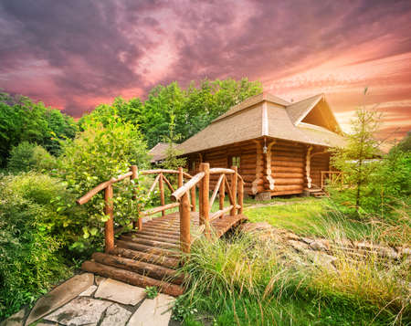 Wooden house and bridge under dramatic skyの写真素材