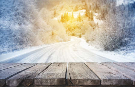 Wooden planks with winter mountain road in backgroundの写真素材