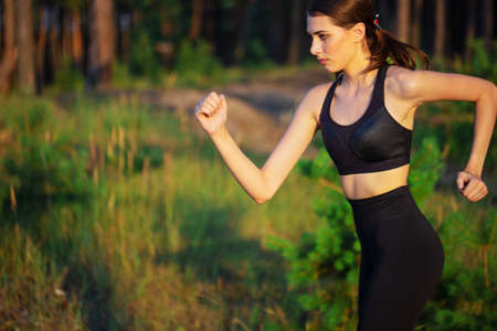 Portrait of beautiful running girl in forestの写真素材