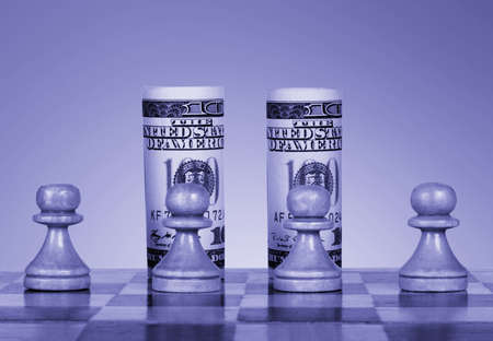 Chess pawns and one hundred dollar bills in place of king and queenの写真素材