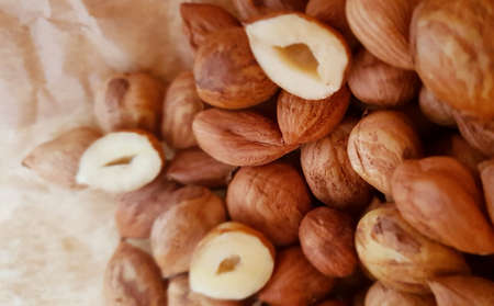 Close-up of a heap peeled hazelnuts, whole and half one, lying on crumpled paper in a bird's eye viewの写真素材