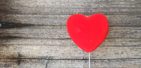 Conceptual image for Valentine's day with red heart on a white handle in front of old rustic grunge...