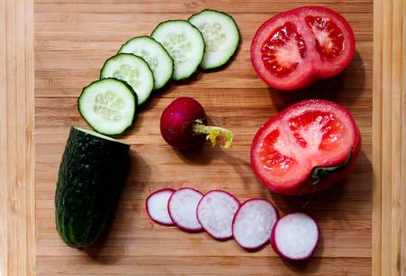 Vegetables, cucumbers, radish and tomatoes are cut into rings.の写真素材
