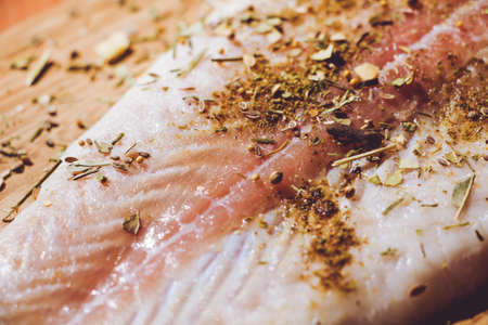 Fresh fish Pangasius is sprinkled with a variety of flavored spices and is ready for roasting.の写真素材