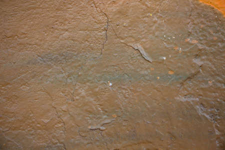 The texture of a brown shade of cracked paint on a concrete wall