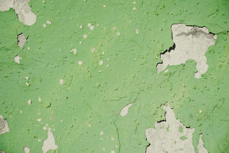 Texture of a green shade of cracked paint on a concrete wallの写真素材