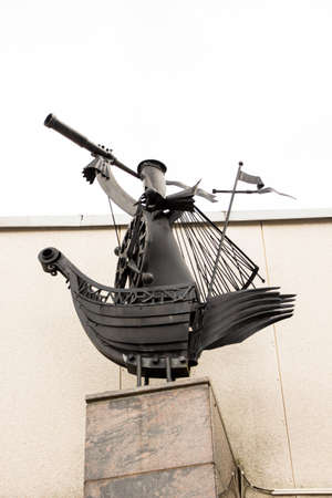 The man on the bow of the ship next to the helm looks into the telescope. The figure is made of metal painted in black.の写真素材