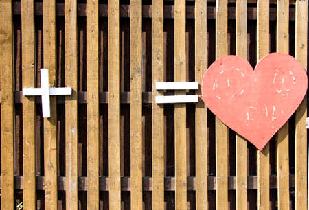 A wooden heart of red color made of wood symbolizes love and wonderful sensuality in love.の写真素材