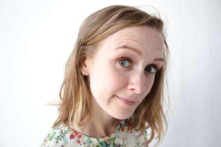 A very beautiful girl with her hair down and in a dress with floral patterns on a white background....