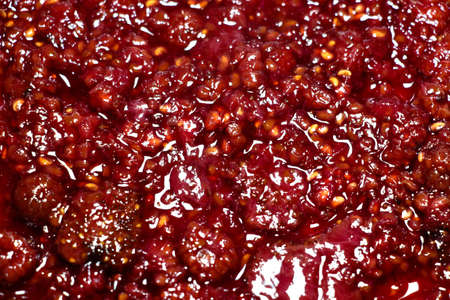 A tasty and fresh raspberry jam is poured on the dough.