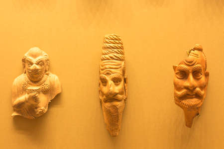 Several ancient head casts are suspended on a pink shade. Culture of certain people.