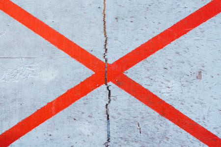 The lines are painted on a wooden surface. The lines of intersect and create a cross. The...