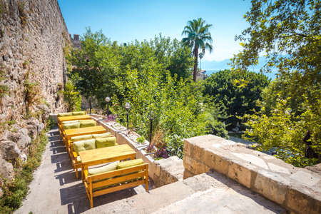 Tables and seats are on the stone terrace. A good place to relax surrounded by palm trees and vegetation.の写真素材