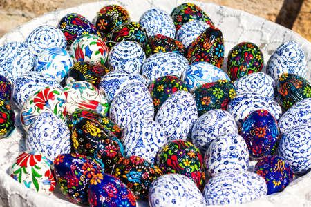 Many eggs in various patterns of a blue shade. Eggs are painted by Easter and stacked in a large...