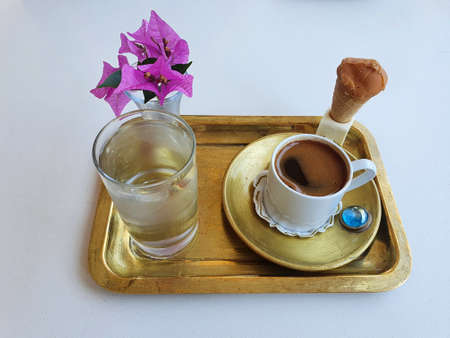 Delicious, strong and aromatic Turkish coffee. Serving with delicious ice cream and a beautiful pink flower.の写真素材